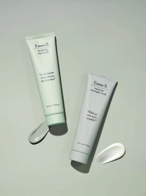 Two tubes of Emma S. skincare products with light green and white lotion, on a light green background, showcasing beauty essentials.