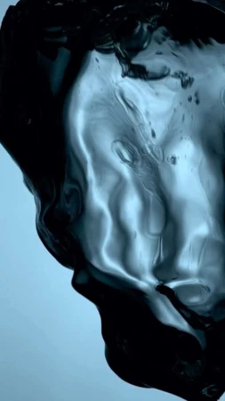 Abstract shot of swirling dark liquid on a gradient blue background, captured in a studio environment for a dynamic visual effect.