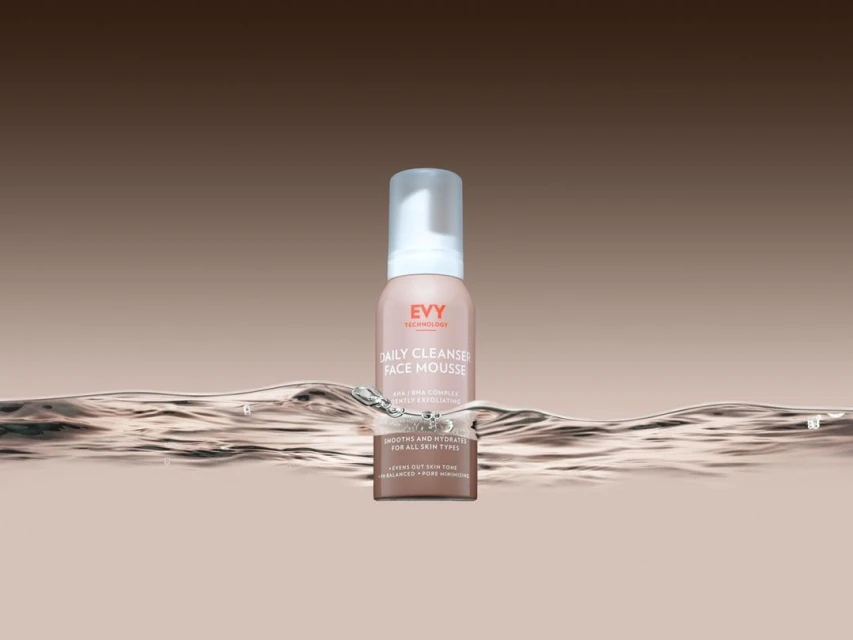 Close-up studio shot of EVY Technology Daily Cleanser Face Mousse, set against a soft gradient background and water ripple effect.