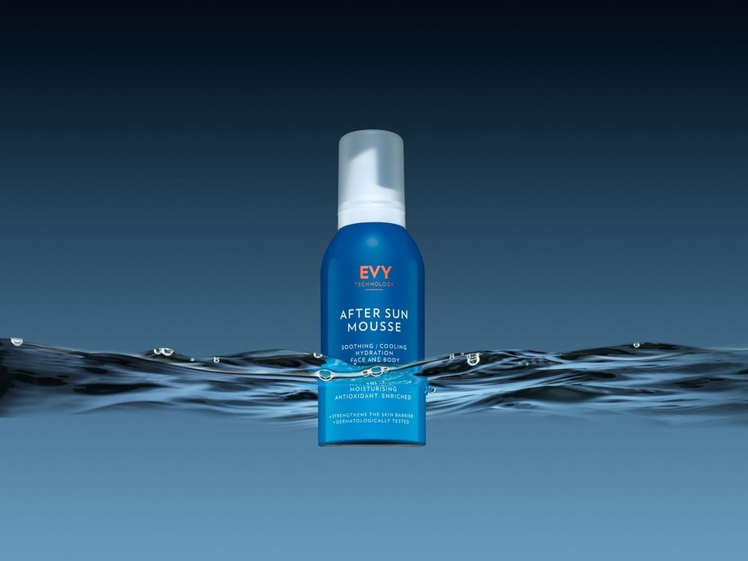 Blue bottle of Evy Technology After Sun Mousse displayed in an underwater setting with water ripples against a gradient blue background.
