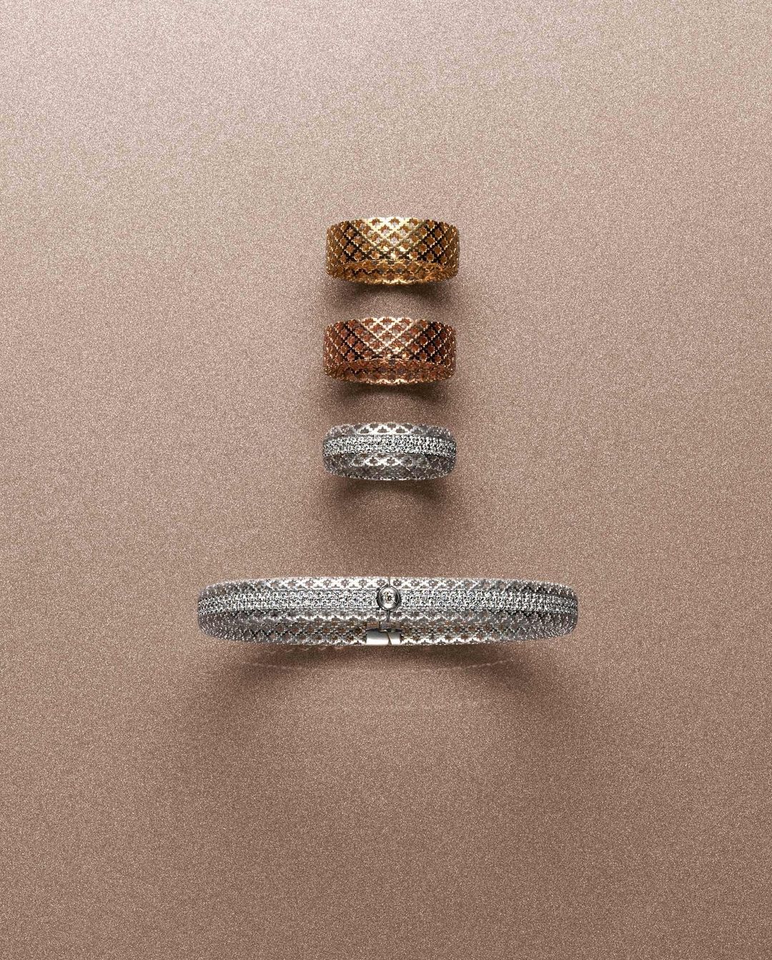 Still life featuring a silver bracelet and gold, rose gold, and silver rings with a woven design arranged on a tan background.