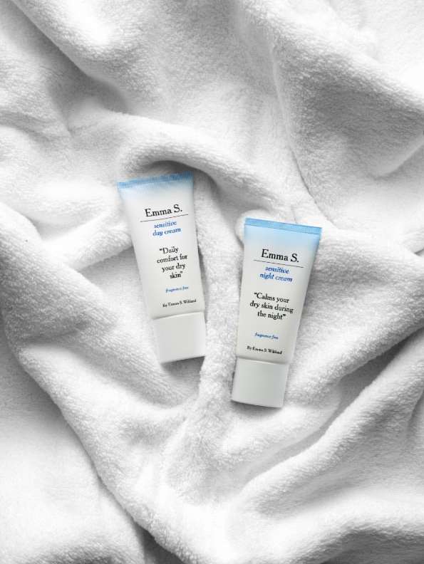 Two Emma S. sensitive day and night cream tubes on a white towel. Beauty product shot.