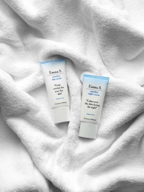 Two Emma S. sensitive day and night cream tubes on a white towel. Beauty product shot.