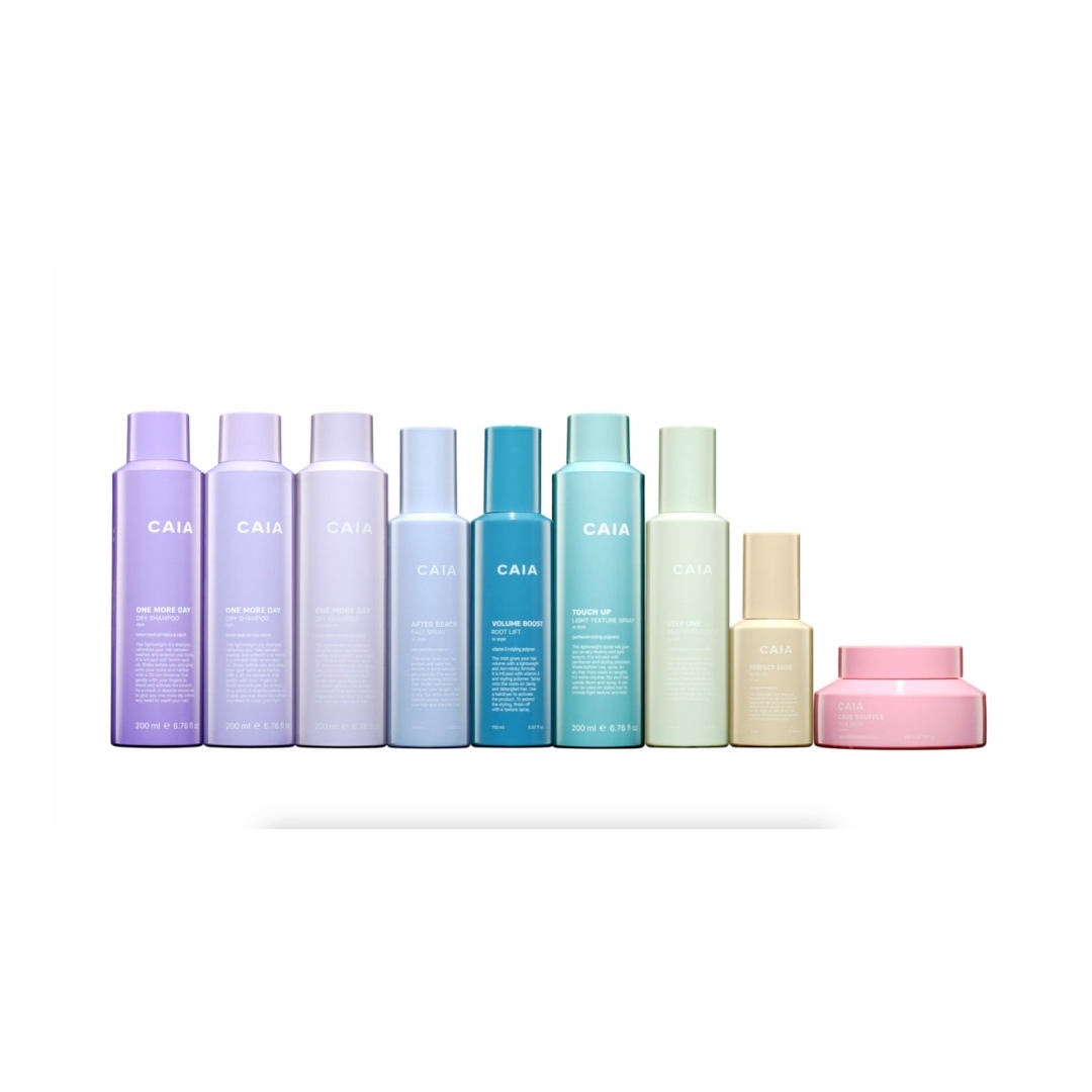 Assorted CAIA Cosmetics products including moisturizers and setting sprays are arranged on a white surface, evenly lit in a product shot.