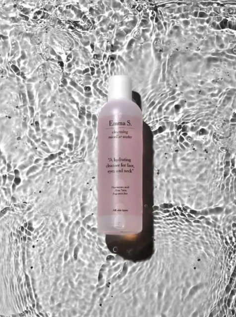 Emma S. cleansing micellar water bottle displayed in rippled water, product shot for the skincare and beauty industry.