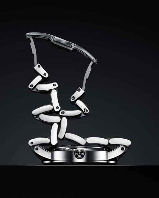 Silver wristwatch with a detached, deconstructed wristband, shot against a stark black backdrop in a studio setting, product photography.