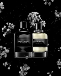 Two perfume bottles with white flowers floating against a black background