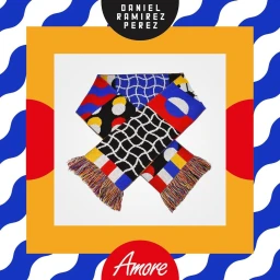 Knitted patterned scarf with colorful geometric shapes and fringe arranged diagonally on a white background
