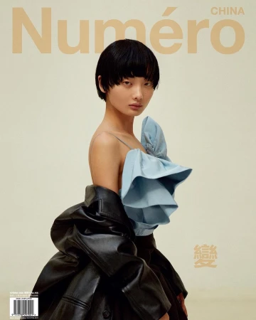 Fashion magazine cover featuring an Asian woman in a blue top and black leather jacket against a light beige background with text.
