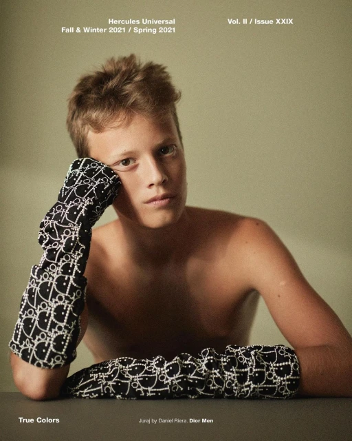Fashion editorial shot of a shirtless young man in patterned gloves, against a neutral background. Magazine cover with text.