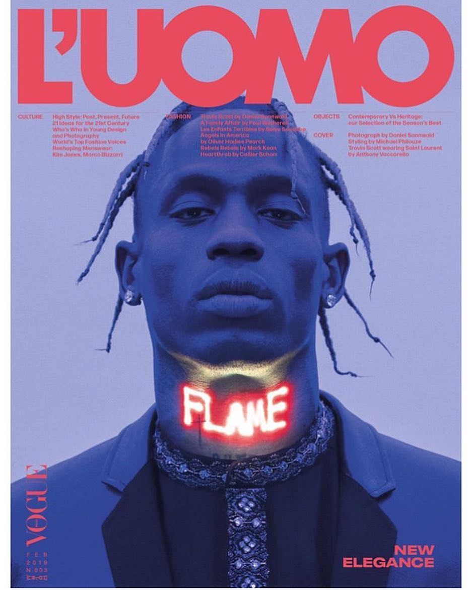L'Uomo Vogue magazine cover featuring a portrait of an adult male with dreadlocks, blue skin tone, and a neon "FLAME" graphic necklace.