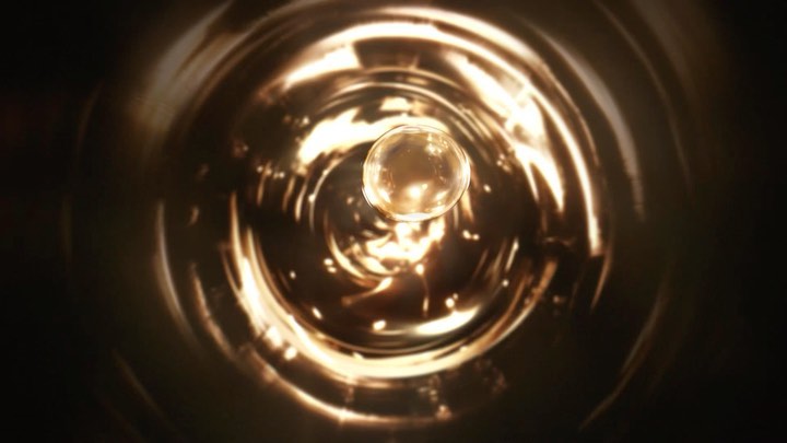 Abstract tunnel view with a golden orb at the center, creating a sense of depth and focus in a swirling, metallic environment.