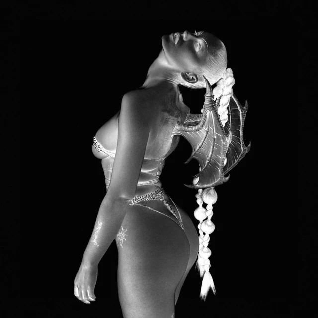 Striking black and white portrait of a woman in creative body paint, posing with feathered wings against a solid black background.