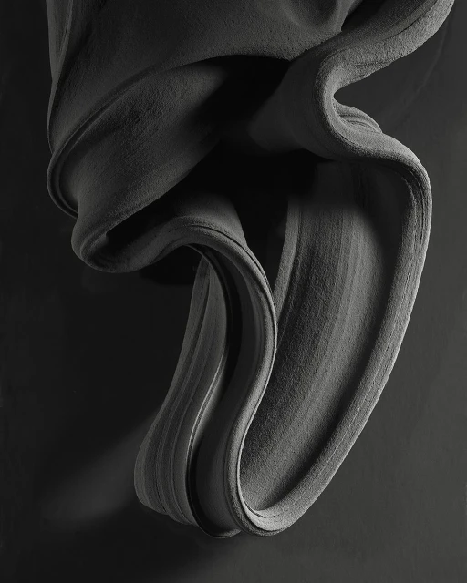 Abstract gray fabric sculpture with textured surface and soft lighting on a dark background, creating depth and movement.