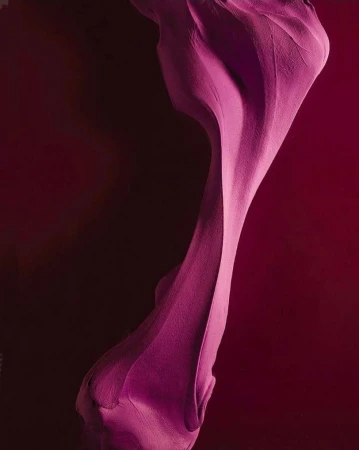 Abstract macro studio shot of flowing fuchsia fabric against dark red background, creating dynamic, elegant curves and folds.