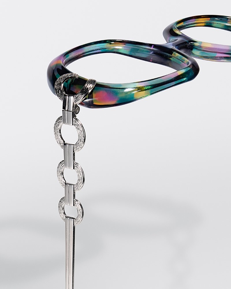 Stylish hair comb on a white background featuring iridescent, reflective, and glossy elements, enhancing the comb's visual appeal.