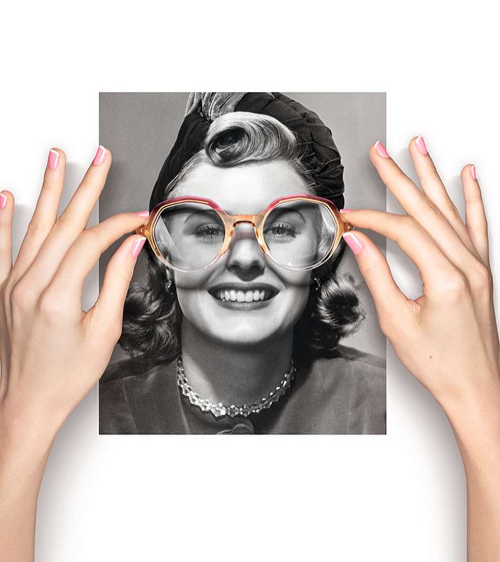 Woman in vintage photo held by hands wearing modern eyeglasses. Retro portrait combined with fashion eyewear on white.