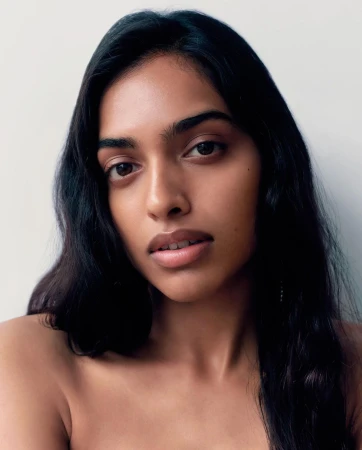 Close-up portrait of a woman with long dark hair and natural expression against a plain white background