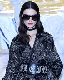 Model wearing dark sunglasses and black patterned top with wide belt by photographer Daniele Rossi in Milan