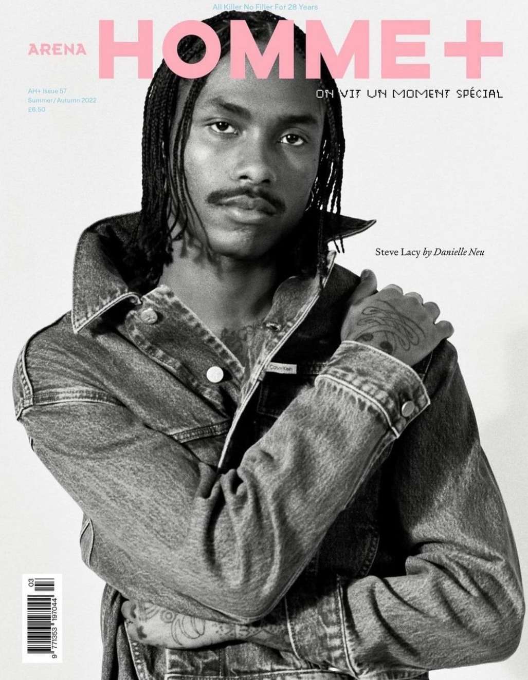 Black and white fashion magazine cover featuring a Black male model wearing a denim jacket with pink text overlay and visible tattoos.