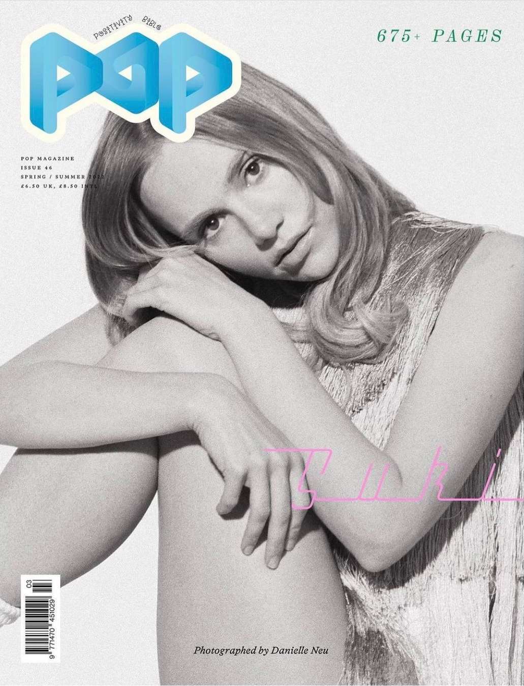 Magazine cover featuring a fair-skinned young woman with long blonde hair, posing indoors with soft lighting and a muted color palette.