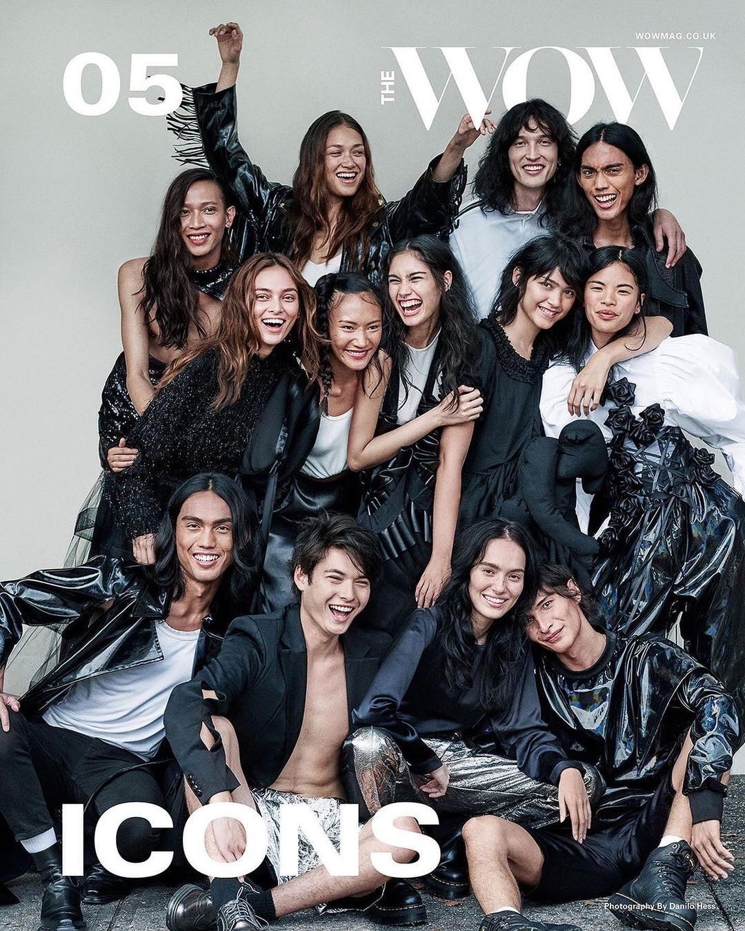 Group of Asian models posing for 'The Wow' magazine cover. Diverse men and women wearing black clothing, standing in a studio. Fashion editorial.