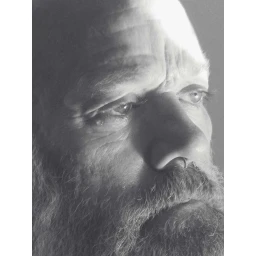 Close-up monochrome portrait of a bearded older man with a nose ring looking pensively