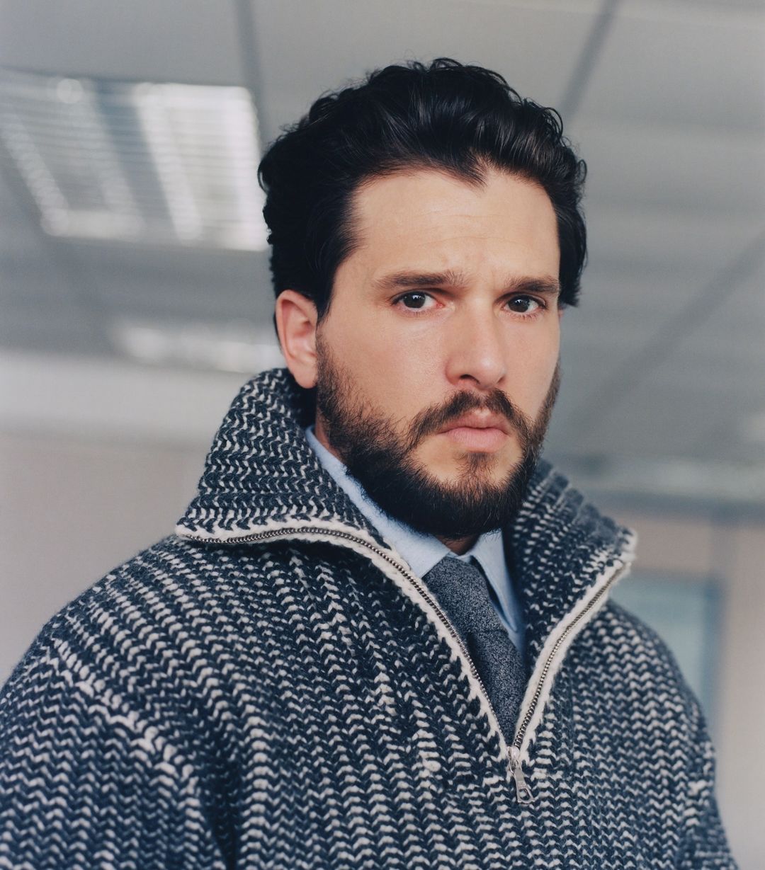 Kit Harington wearing a patterned grey zip-up sweater and tie, photographed by Danny Lowe in London.