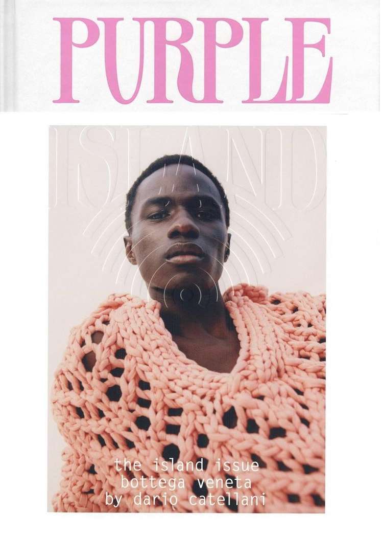 Magazine cover featuring a Black male model wearing a pink knit sweater, set against a light background. The magazine title 'PURPLE' is above.