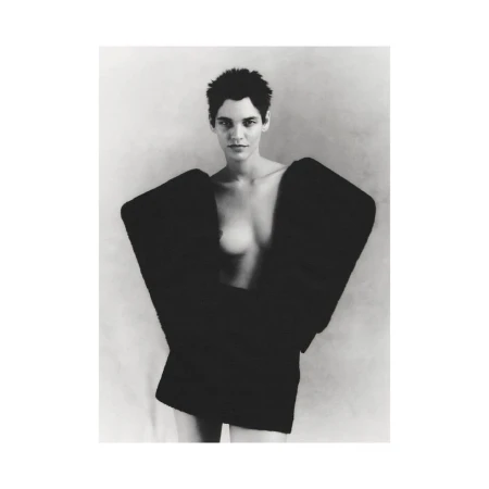 Monochrome portrait of a female fashion model with short dark hair wearing an oversized black jacket against a plain background.