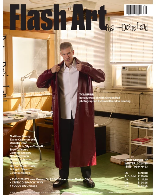 Magazine cover featuring Tom Burr wearing a long, red, leather coat and white shirt with a window and radiator in the background.