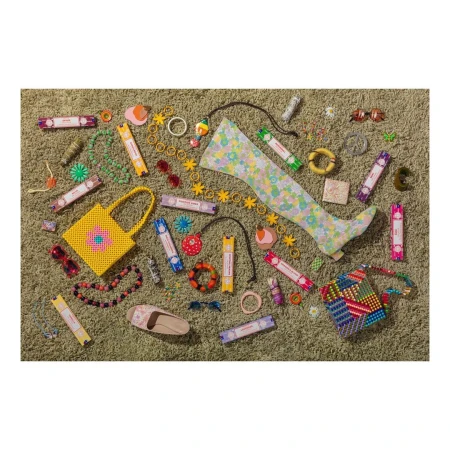 Flat lay of colorful fashion accessories including beaded bags, floral boots, and jewelry on a green shag carpet.