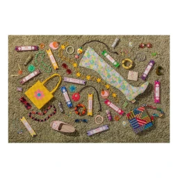 Flat lay of colorful fashion accessories including beaded bags, floral boots, and jewelry on a green shag carpet.