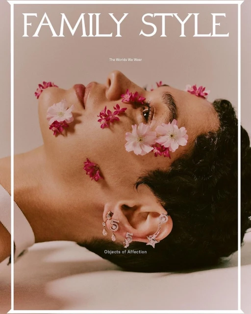 Fashion magazine cover featuring a person with flowers and jewelry on light pink backdrop. The image has editorial and beauty style.