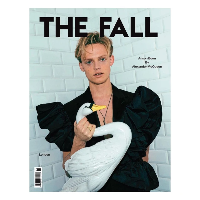 Magazine cover featuring Anson Boon in a black ruffled outfit, holding a white swan statue, set against a tile background.