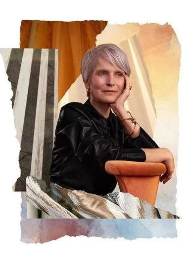 Elegant woman with short grey hair poses in front of a surrealist collage backdrop of stripes, colors, and textured fabrics.
