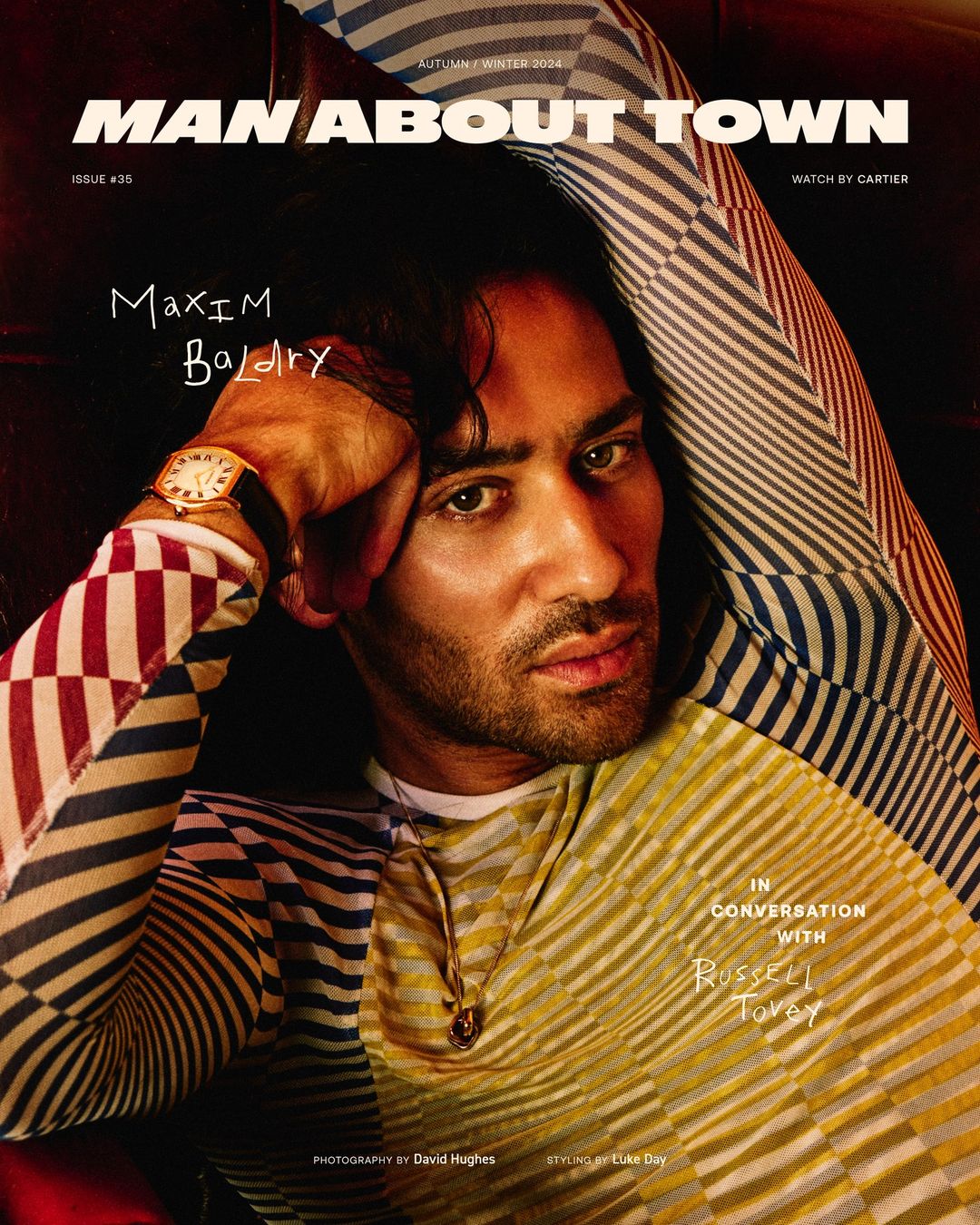 Magazine cover featuring Maxim Baldry in patterned shirt, gold watch, and pendant, with handwritten text and magazine masthead.