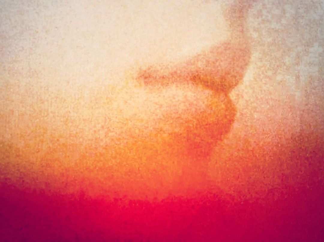 Abstract artistic background with gradient hues of white, yellow, orange, and red, creating a warm and textured visual.