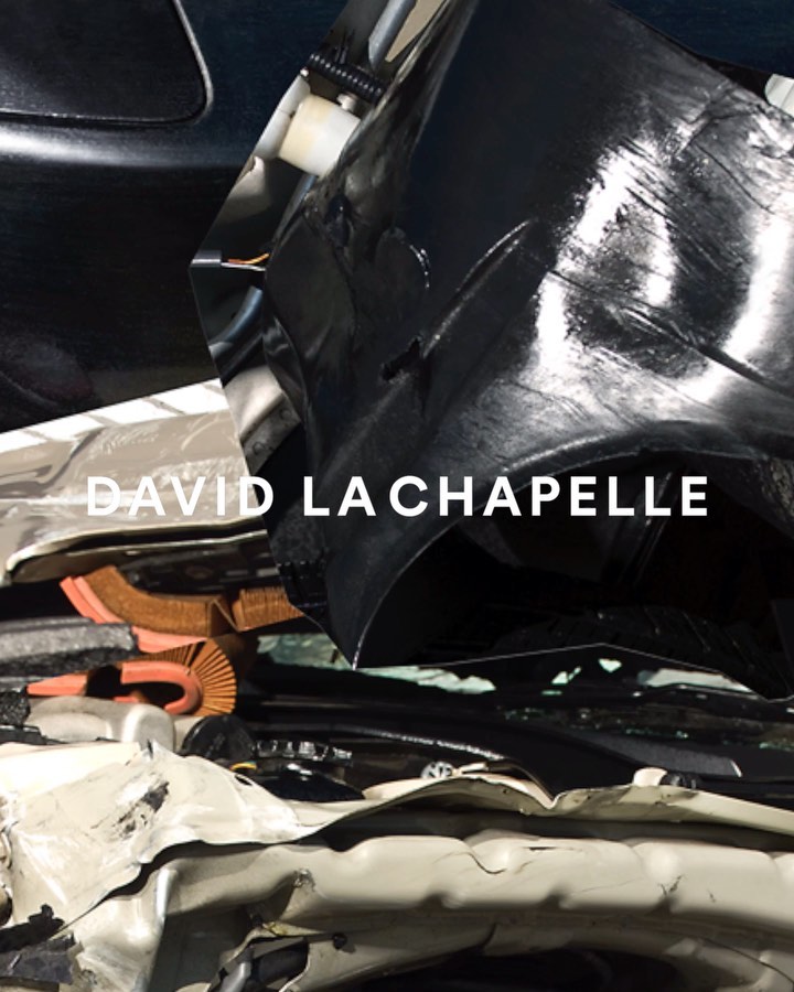 Damaged vehicles in black and white photo. A vehicle is dented. The photo has black glossy parts and a white author's name in the middle.
