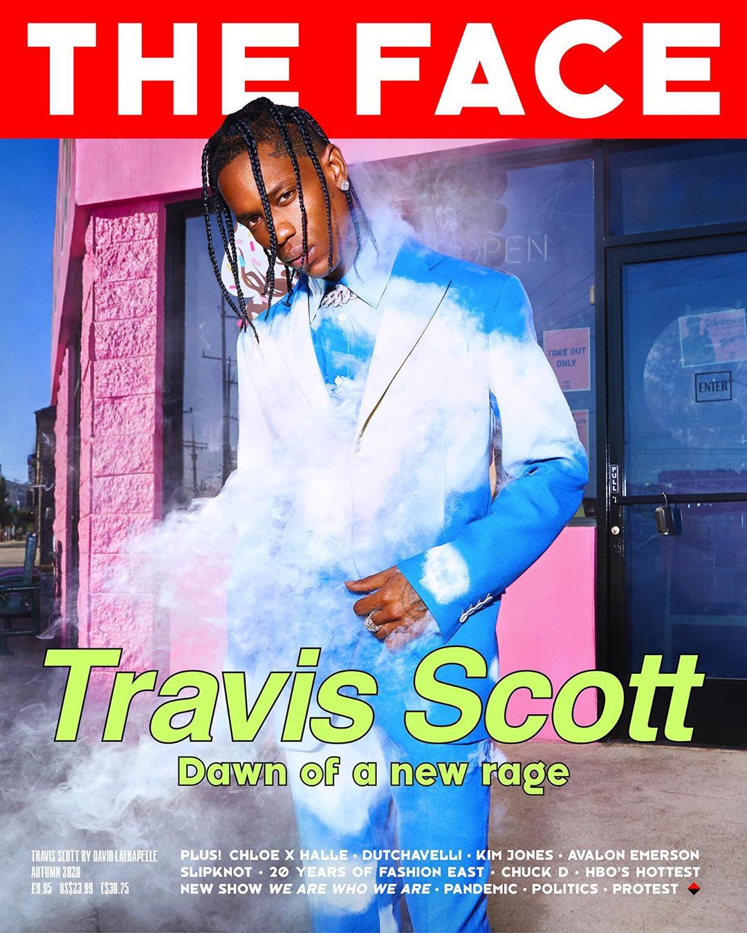 Travis Scott on The Face magazine cover, wearing a blue-and-white suit, standing outside a pink building on a city street, with smoke effect.