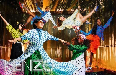 Group of diverse models in colourful patterned outfits posing in a forest set for Kenzo photography by David Lachapelle