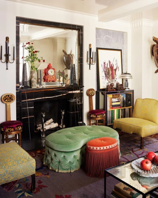 Eclectic living room interior featuring a black marble fireplace, colorful furniture, area rug with floral patterns, and decorative items.
