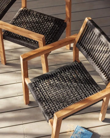 Elevated shot of three wooden-framed chairs with woven seats, showcasing modern outdoor furniture on a wood surface with a blue book.