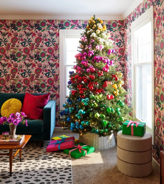 Festive Christmas tree in living room decorated with rainbow-colored ornaments, presents wrapped in green, pink, blue, and yellow.