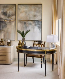 An ornate black and gold writing desk with matching chair and crystal lamp in a bright home office featuring large abstract art.
