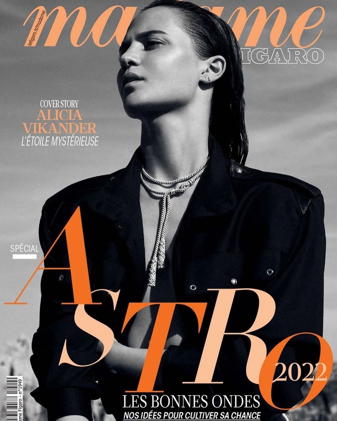 Black and white fashion magazine cover featuring Alicia Vikander. She wears a black jacket and silver necklace against a neutral background.