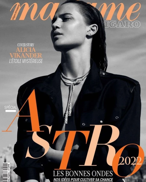 Black and white fashion magazine cover featuring Alicia Vikander. She wears a black jacket and silver necklace against a neutral background.