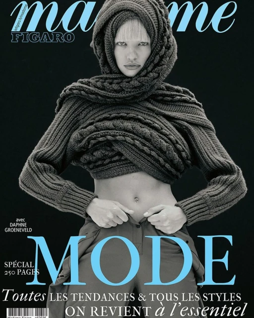 Magazine cover featuring a female model in a grey hooded knit sweater and olive pants, set against a dark grey backdrop with light blue title text.