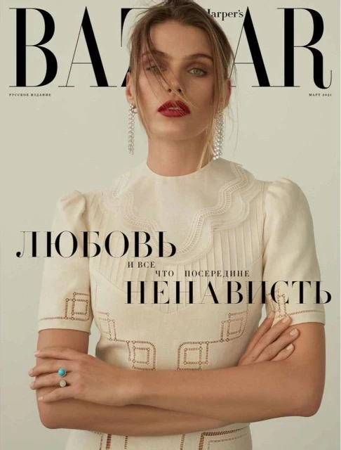 Harper's Bazaar cover featuring a Caucasian female model with red lipstick and long earrings, wearing a white dress, arms crossed.
