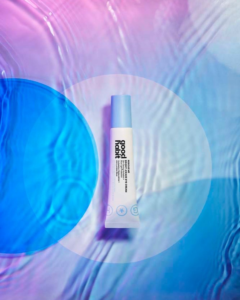 Good Habit skincare product tube on a rippled blue and pink background with a translucent blue circle adding visual interest.